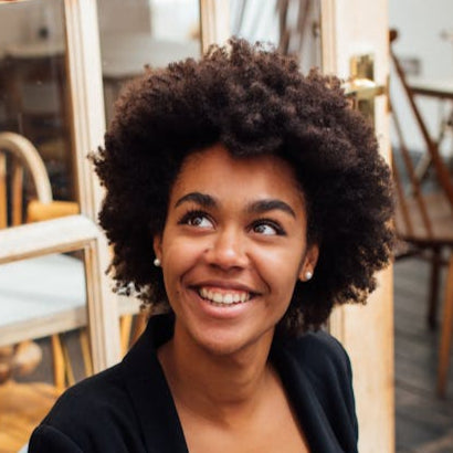 Woman smiling at a man in a casual setting with a laptop on a table.